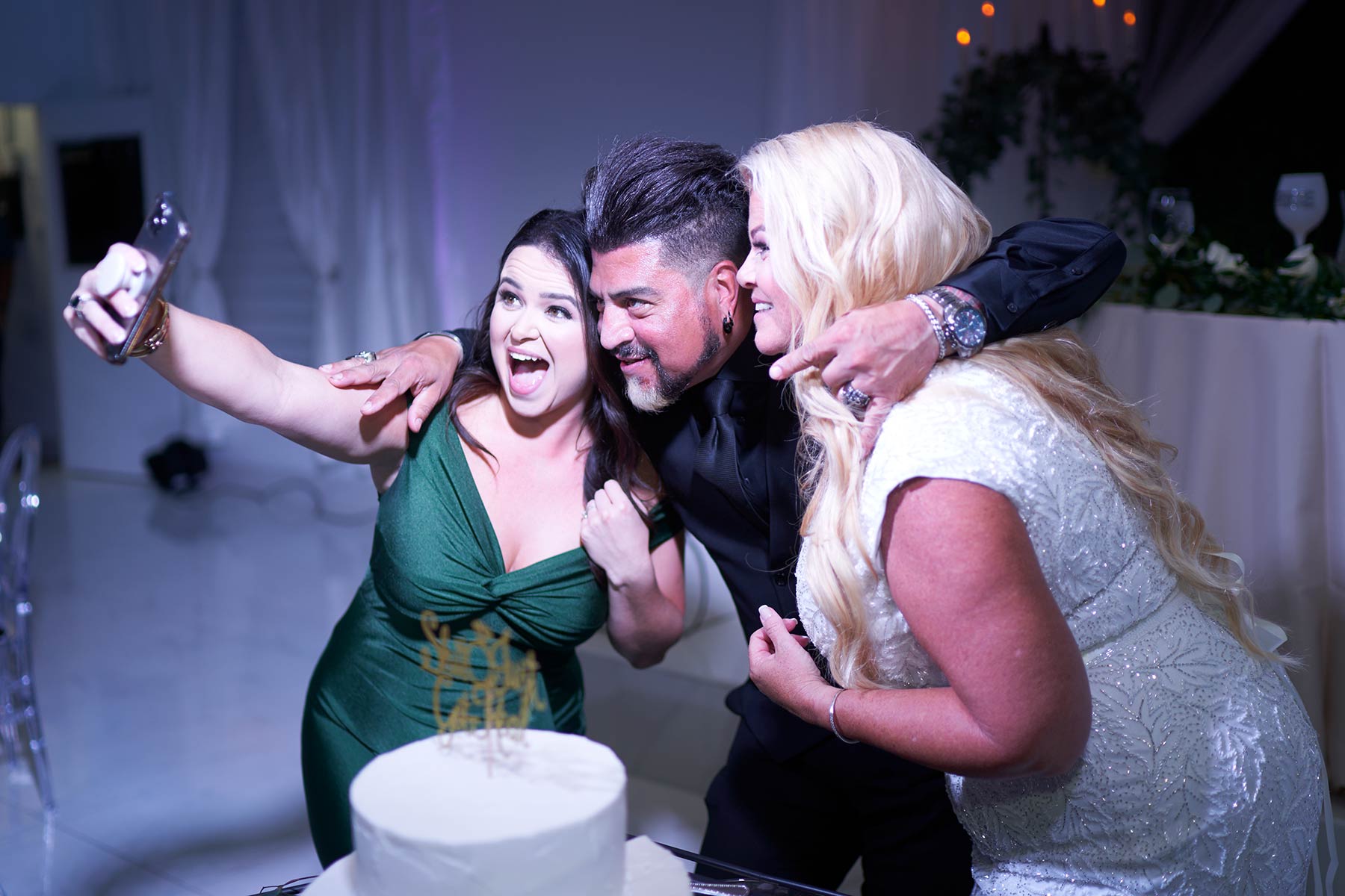 Bride-and-groom-posing-for-selfie-with-millenial-guest