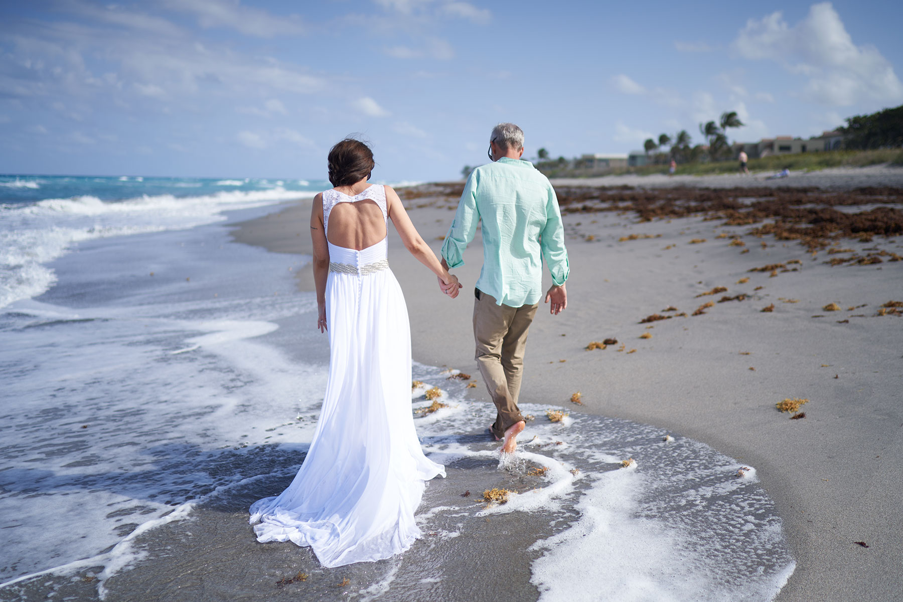 Groom-walking-with-bride-on-beach-at-spring-wedding