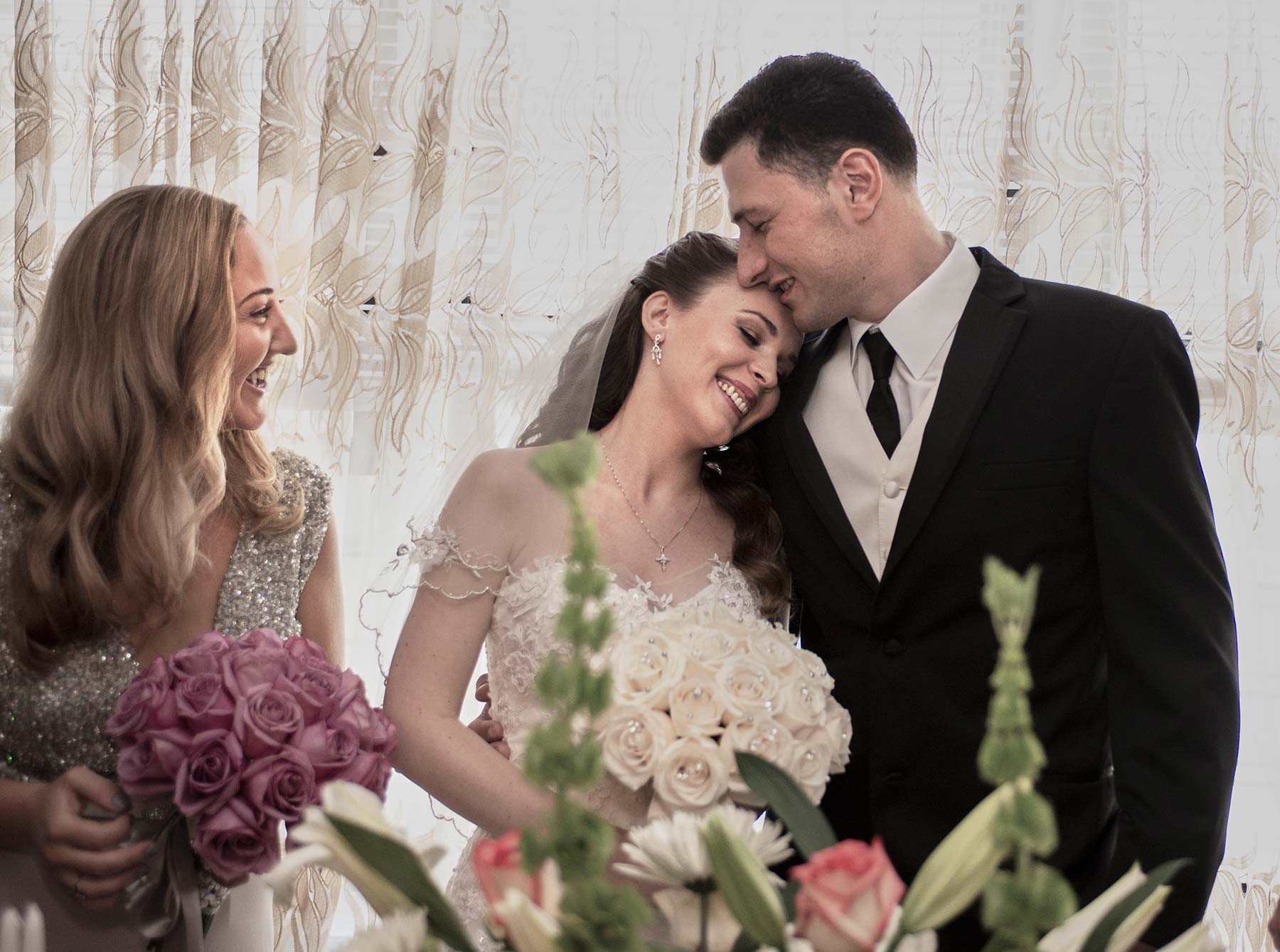 Young Bride Kate smiling with groom with bridesmaid