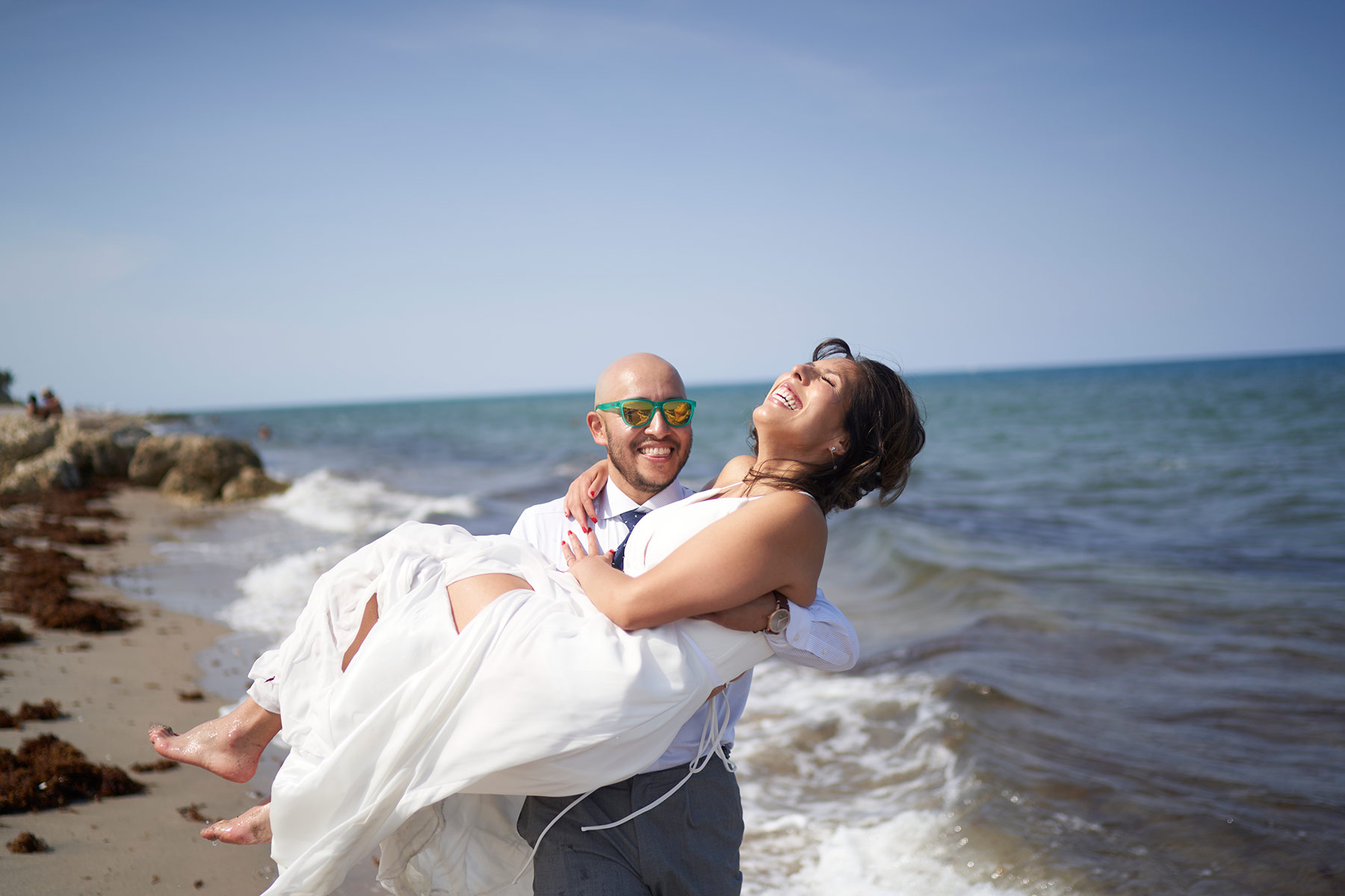 Young-Groom-holding-his-bride-up-on-Beach-after-wedding-ceremony